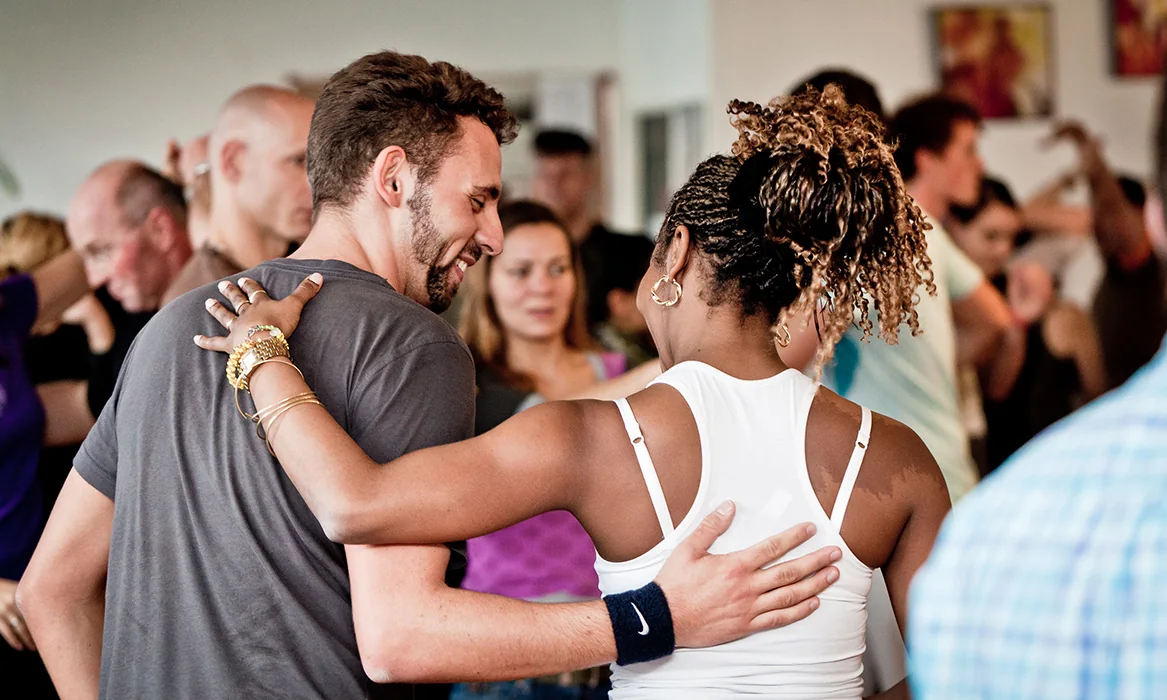 Tanzpaar umarmt sich lächelnd beim Salsa-Kurs der Salsa Company Heilbronn